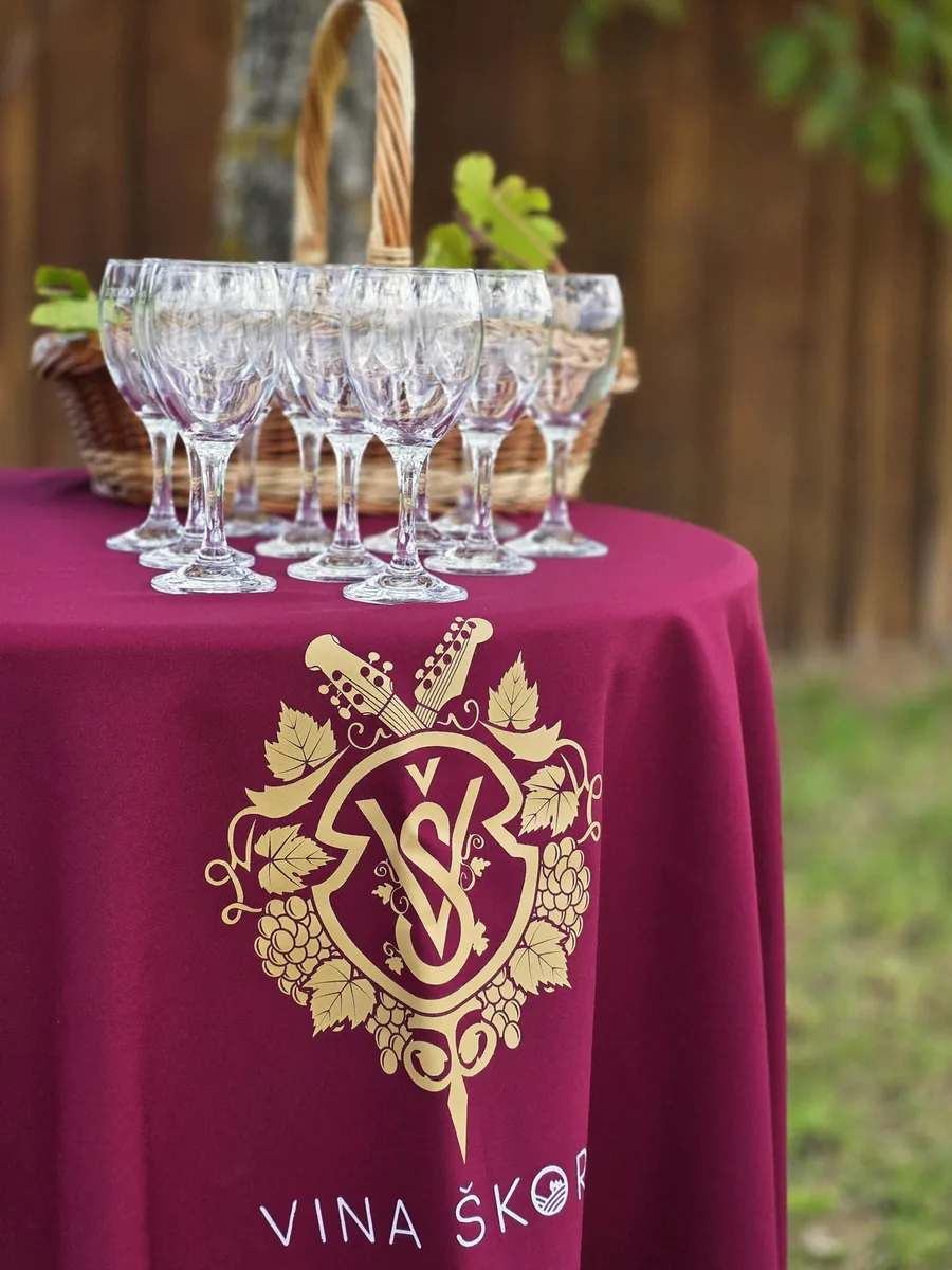 Stol s čašama i stolnjakom Vina Škoro u vinogradu